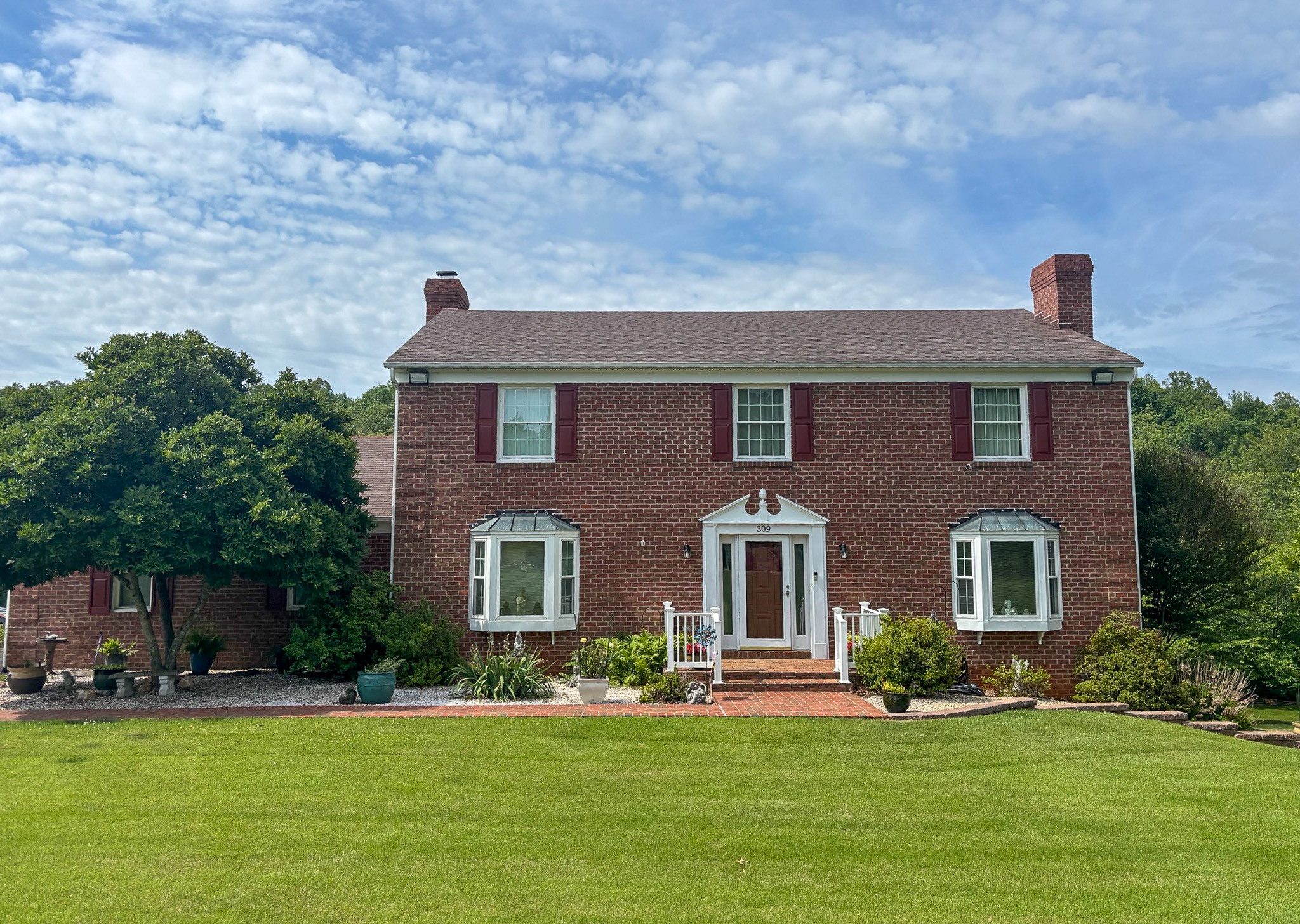 Brick two-story house with a manicured lawn and front porch belonging to group home providers Laura Gunter-Vaughan and Ryan Branigan in Madison Heights, Virginia.