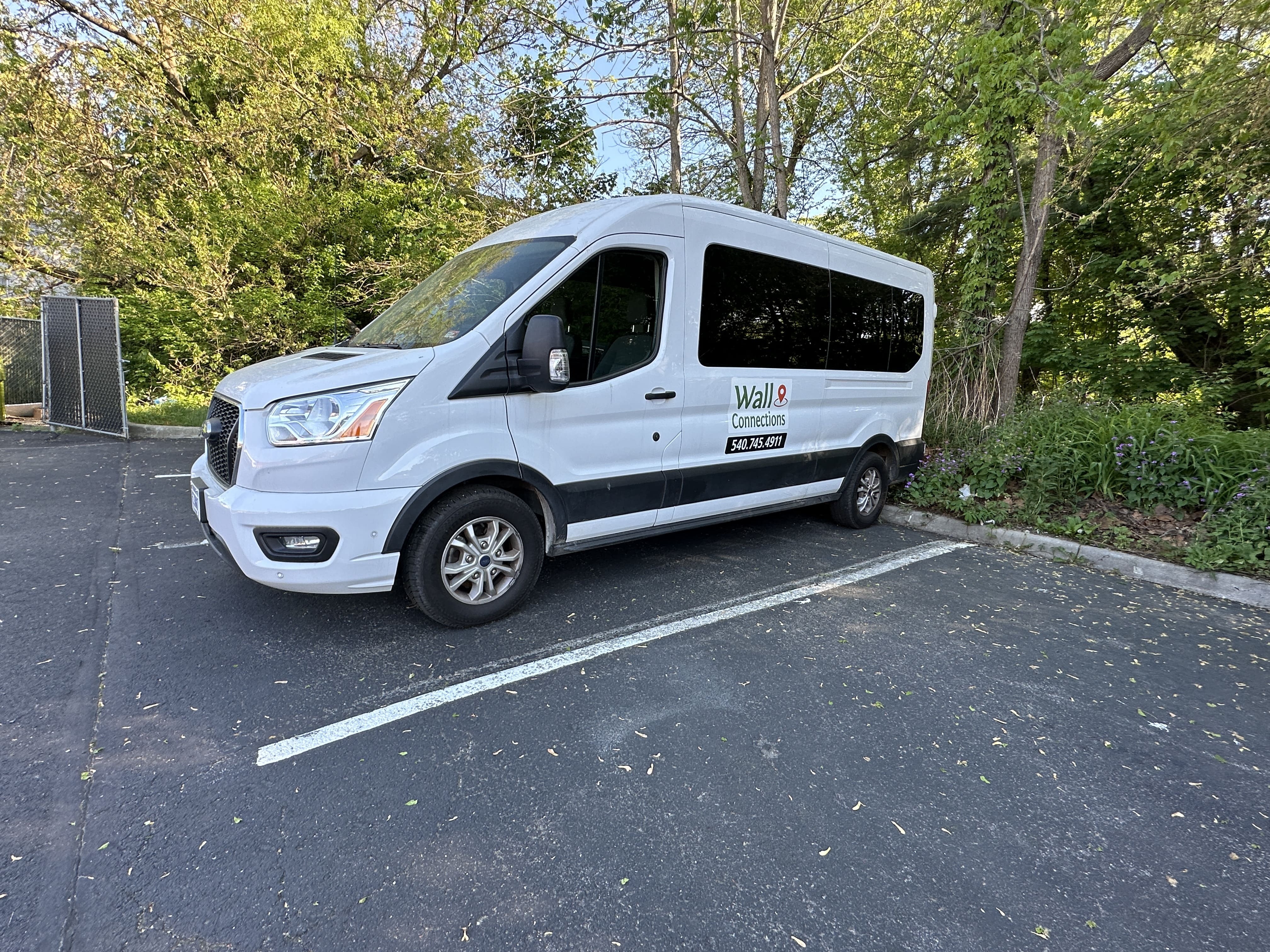 White wheelchair-accessible van with a Wall Connections logo parked in a lot