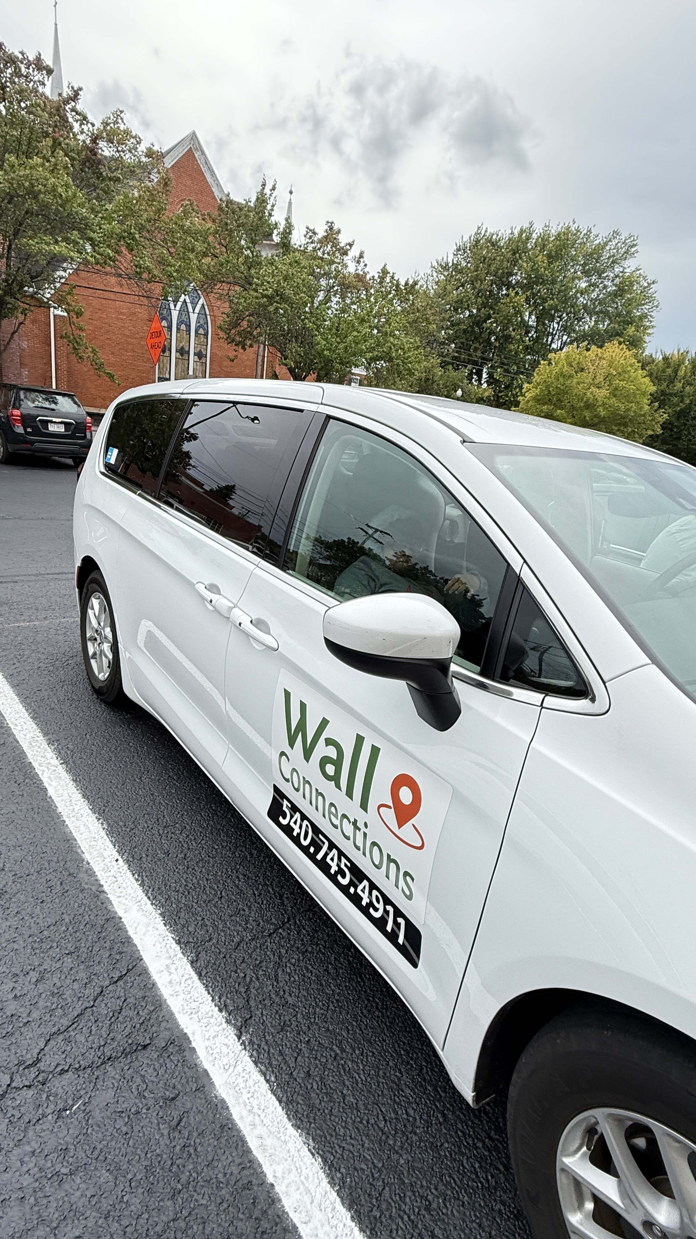 White Wall Connections sedan viewed from the passenger side in a parking lot