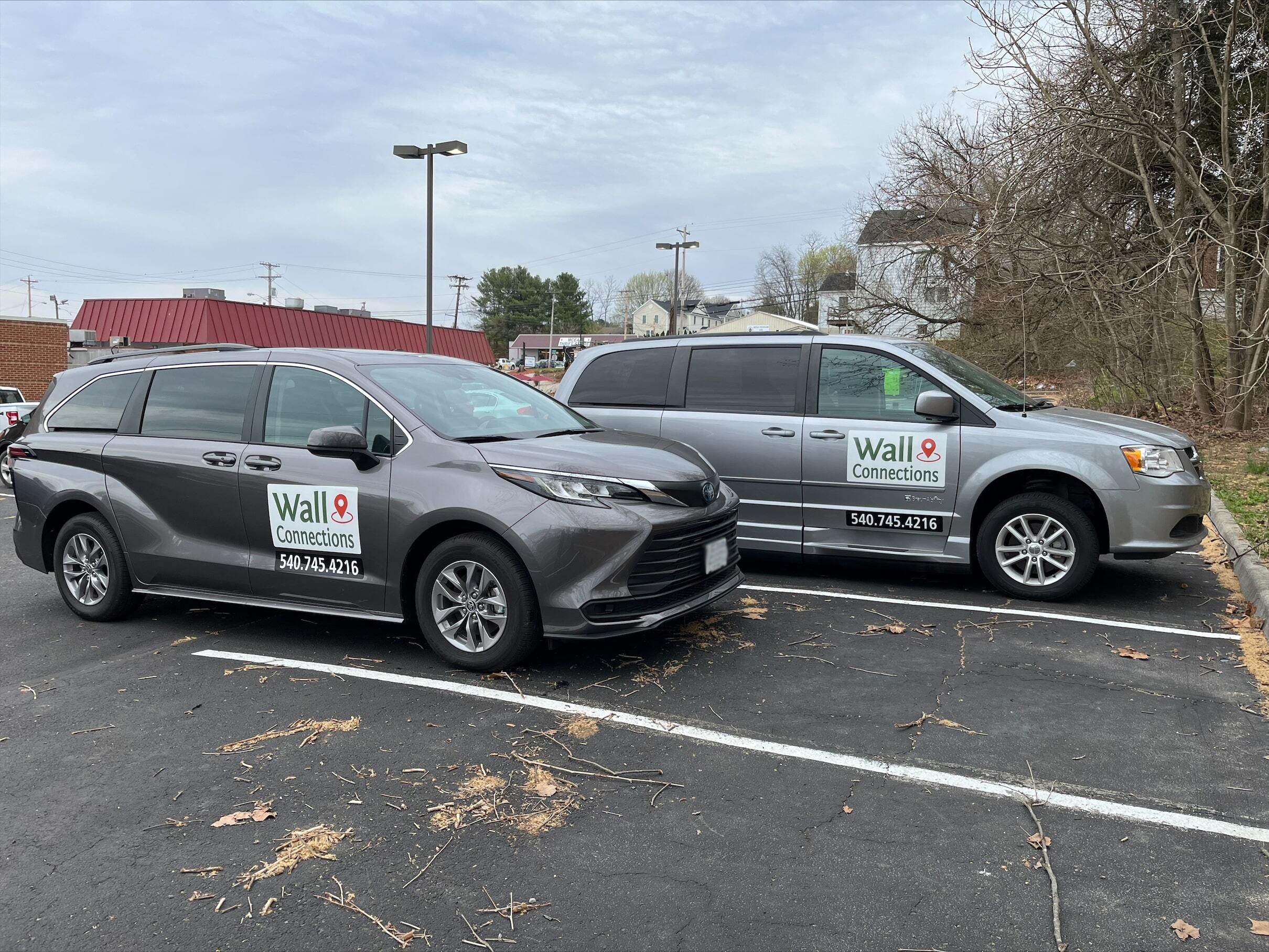 Two grey vans with Wall Connections signage parked in a lot